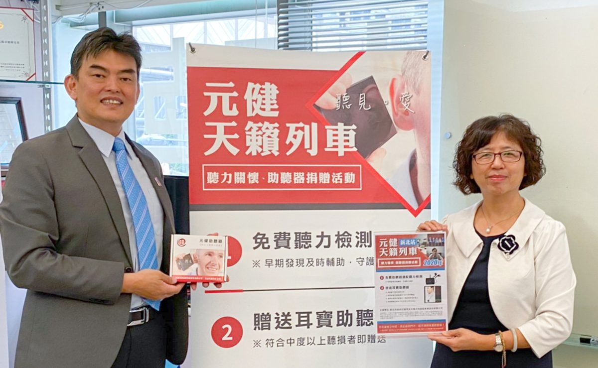 元健天籟列車雙北站啟動合影,一位西裝男士與一位白外套女士手持活動傳單,站在寫有「元健天籟列車 聽力關懷・助聽器捐贈活動 免費聽力檢測 贈送耳寶助聽器」的立牌旁,點擊閱讀〈元健公益慈善》天籟列車雙北站正式啟動!〉