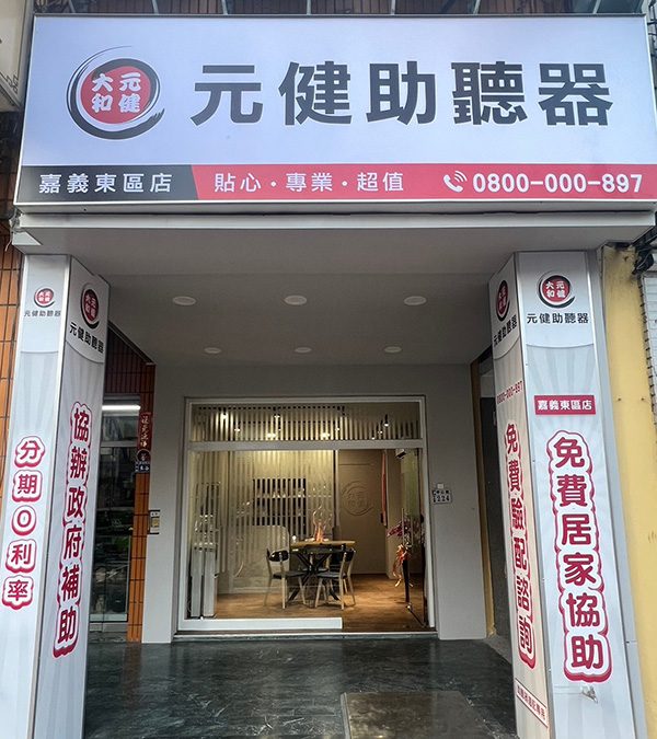 元健助聽器嘉義東區旗艦門市外觀,白色招牌印有元健助聽器標誌、嘉義東區店、貼心專業超值與免付費專線0800-000-897,兩側紅白直式招牌寫著分期0利率與免費居家協助,玻璃門內可見明亮的門市空間。
