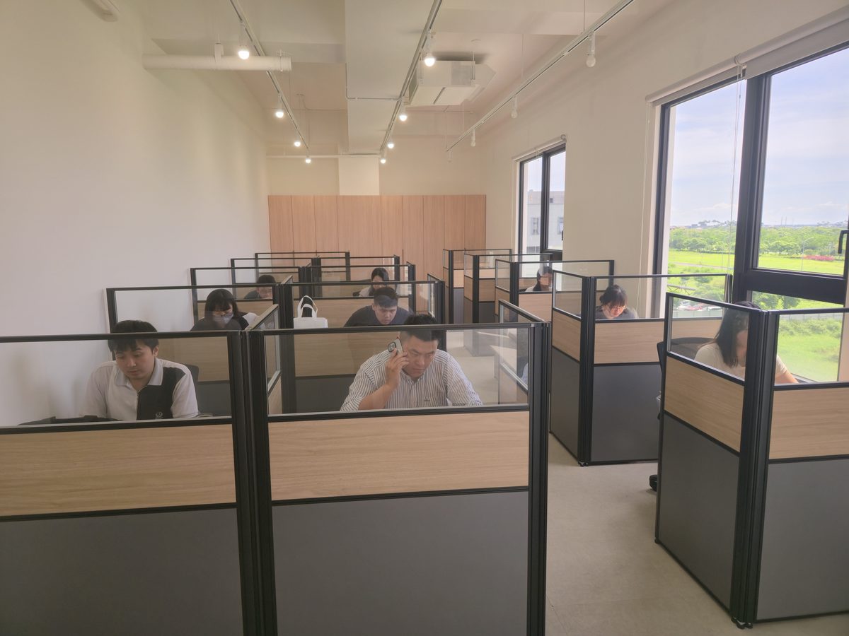 元健助聽器宜蘭企業總部客服中心，客服人員在明亮的辦公座位接聽電話、協助預約與聽力關懷諮詢