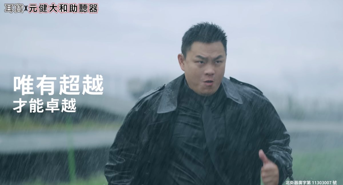 元健助聽器 Mimitakara 耳寶廣告影片截圖:身穿黑色雨衣的男士在大雨中奔跑並比出讚的手勢,畫面文字「唯有超越 才能卓越」,左上標示元健大和助聽器,點擊觀看〈耳寶助聽器_Vo.6【無所畏懼】2024〉